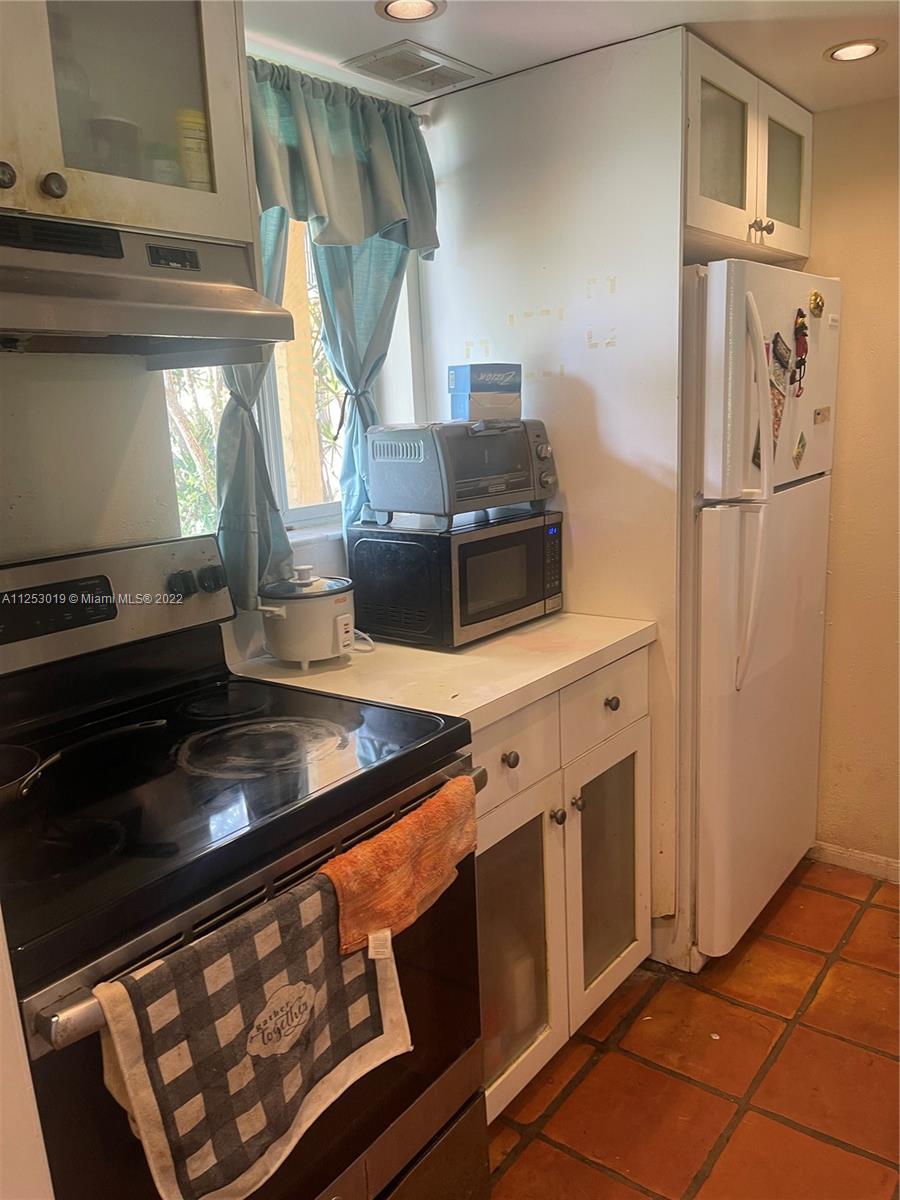 812 Southwest 9th St Circle, Unit 101 Boca Raton, FL 33486 - Photo 12 of 15 a kitchen with stainless steel appliances granite countertop a stove and a microwave