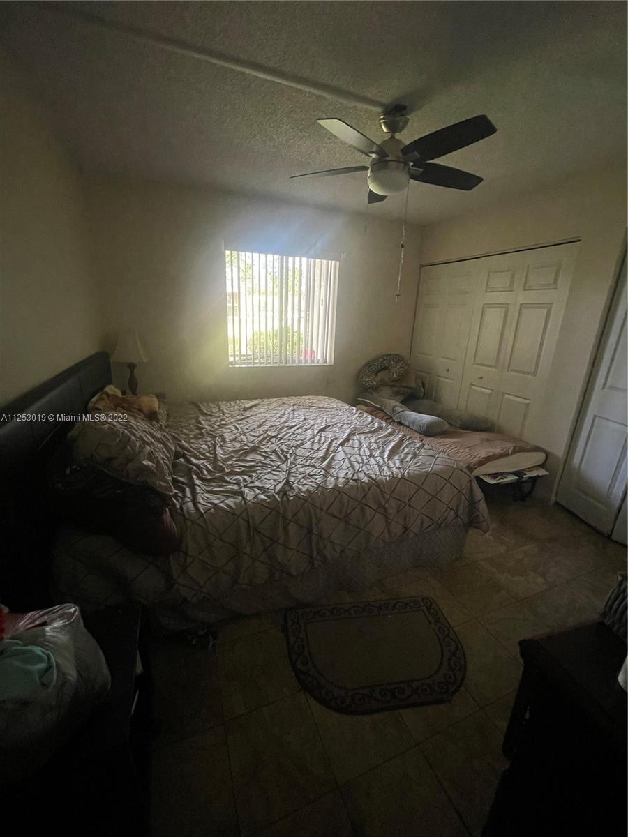 812 Southwest 9th St Circle, Unit 101 Boca Raton, FL 33486 - Photo 8 of 15 a bed sitting in a bedroom next to a window