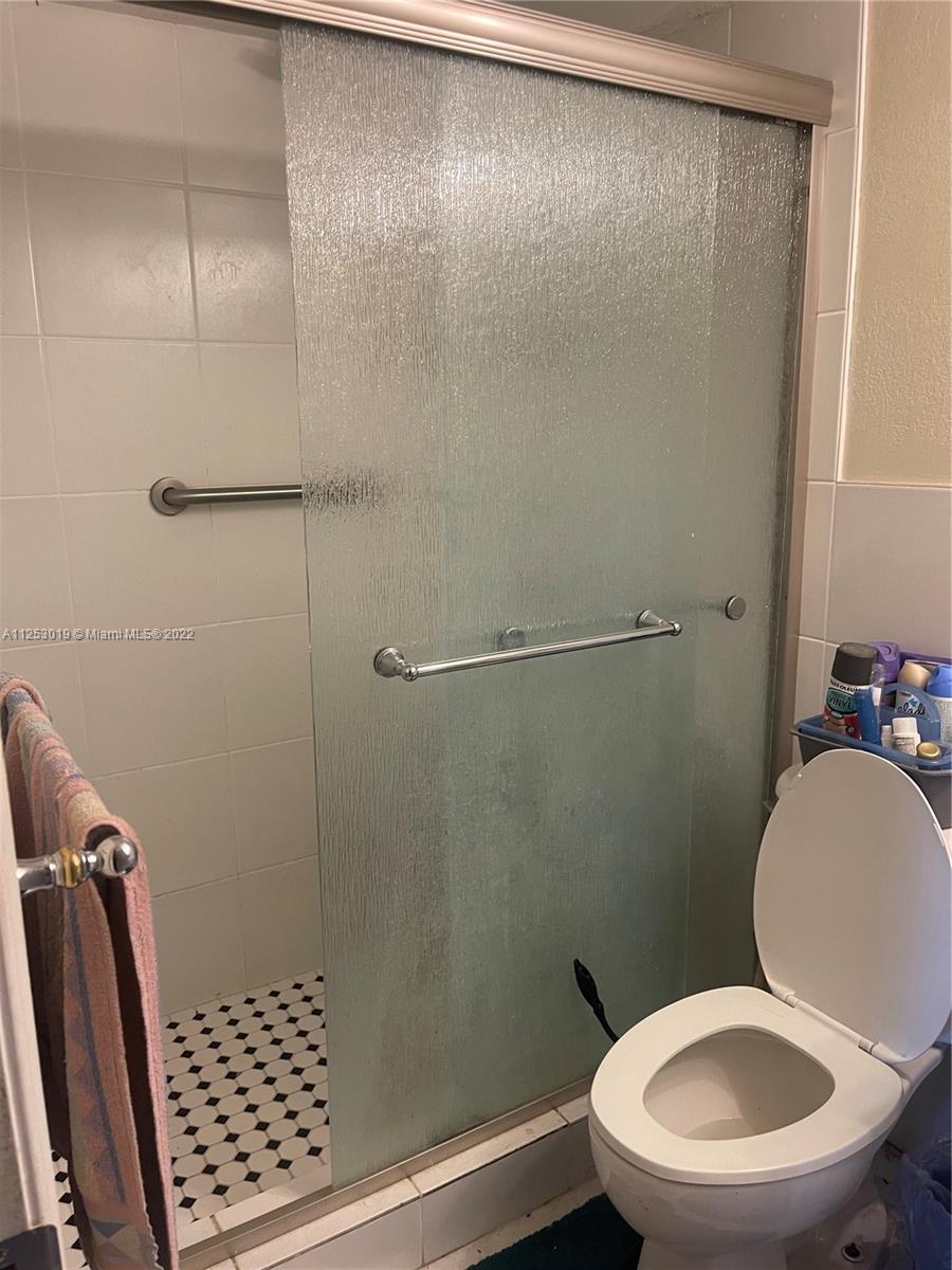 812 Southwest 9th St Circle, Unit 101 Boca Raton, FL 33486 - Photo 9 of 15 a white toilet sitting next to a bathroom sink