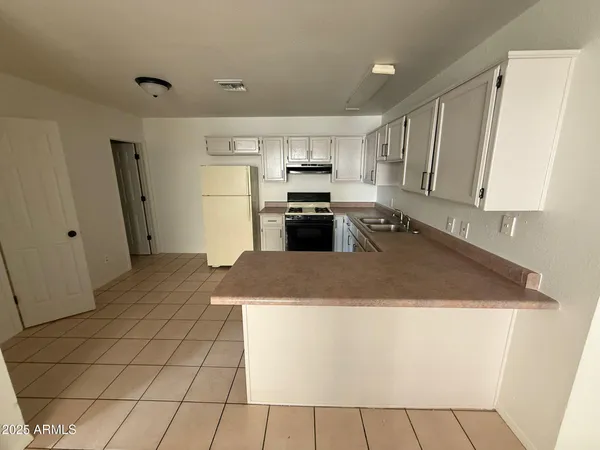 a kitchen with stainless steel appliances granite countertop a refrigerator a stove a sink a microwave and white cabinets