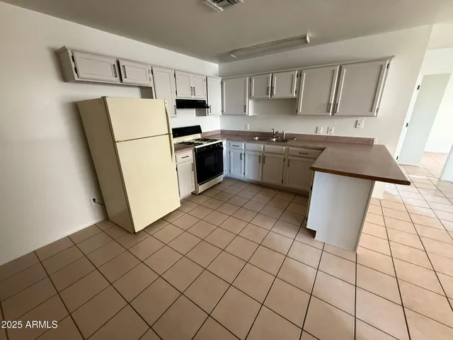 a kitchen with a stove a sink dishwasher and a refrigerator
