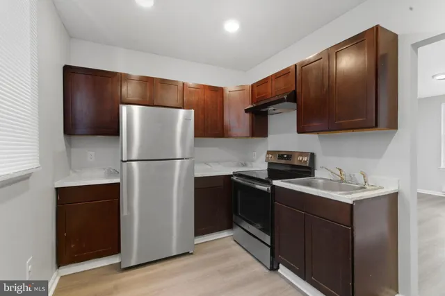 a kitchen with stainless steel appliances granite countertop a refrigerator a stove a sink and a microwave