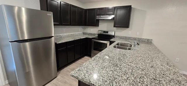 a kitchen with a refrigerator and a sink