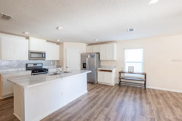 a kitchen with white cabinets and white appliances