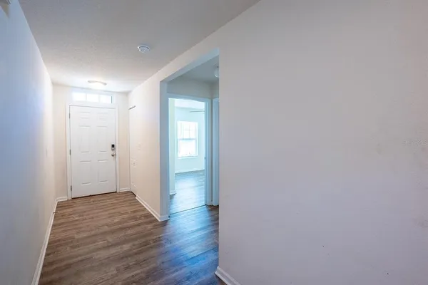 a view of an empty room with wooden floor