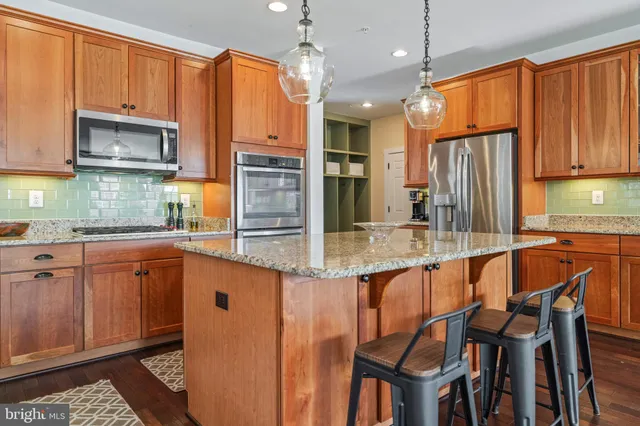 a living room with stainless steel appliances furniture a fireplace a flat screen tv and a fireplace