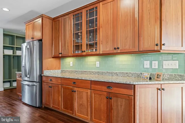a living room with furniture kitchen view and a wooden floor