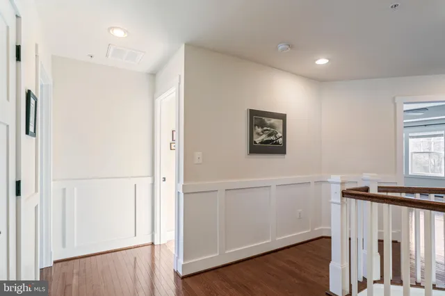 a view of a kitchen with refrigerator and wooden floor