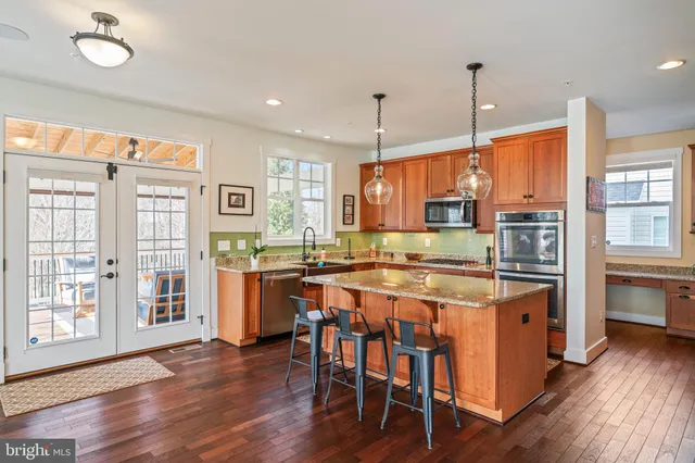 a kitchen with stainless steel appliances granite countertop a refrigerator a sink and a stove