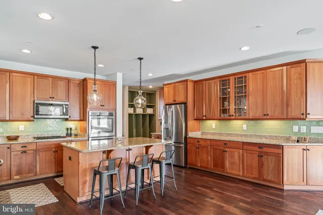 a kitchen with stainless steel appliances granite countertop a sink and a large window