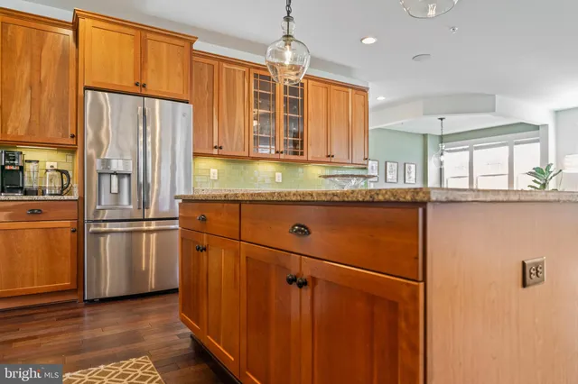 a kitchen with granite countertop wooden cabinets a sink and dishwasher