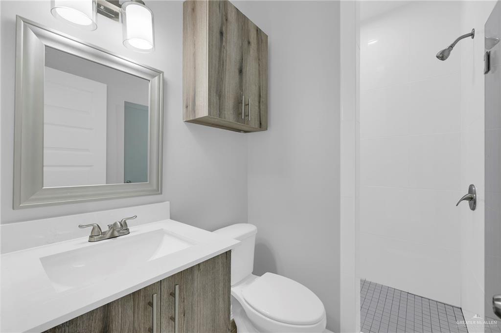 504 Bridget Street Weslaco, TX 78596 - Photo 12 of 23 a bathroom with a sink vanity mirror and toilet