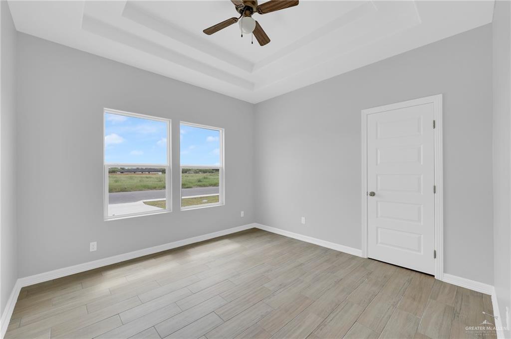 504 Bridget Street Weslaco, TX 78596 - Photo 13 of 23 an empty room with wooden floor fan and windows