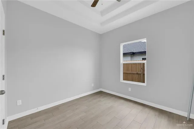 an empty room with a window and a ceiling fan