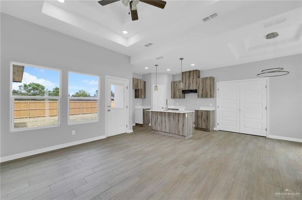 504 Bridget Street Weslaco, TX 78596 - Photo 4 of 23 a large white kitchen with stainless steel appliances kitchen island granite countertop a stove and a large window