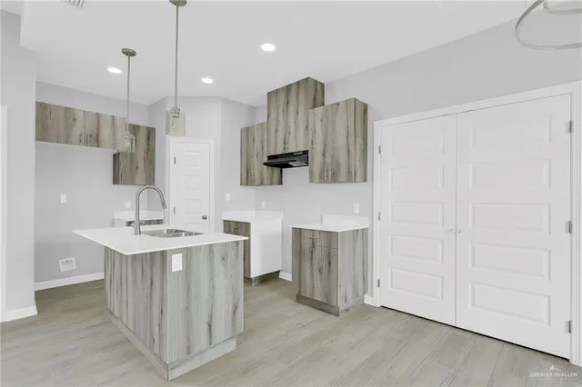 a kitchen with kitchen island a sink stainless steel appliances and cabinets