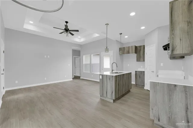 a large kitchen with a lot of counter space and wooden floor