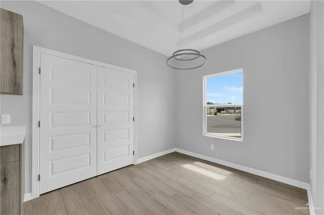 a view of a room with wooden floor and white doors