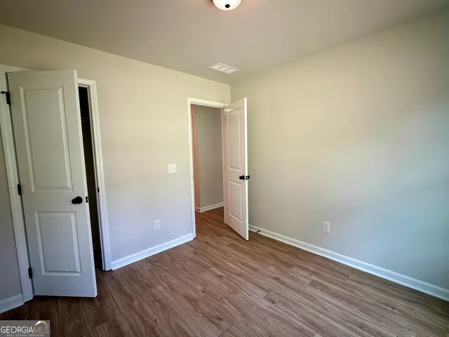 an empty room with wooden floor and entrance