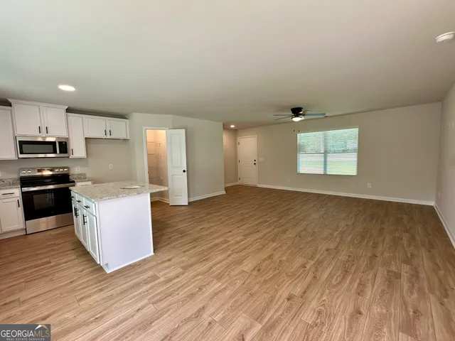 a view of kitchen with wooden floor and electronic appliances