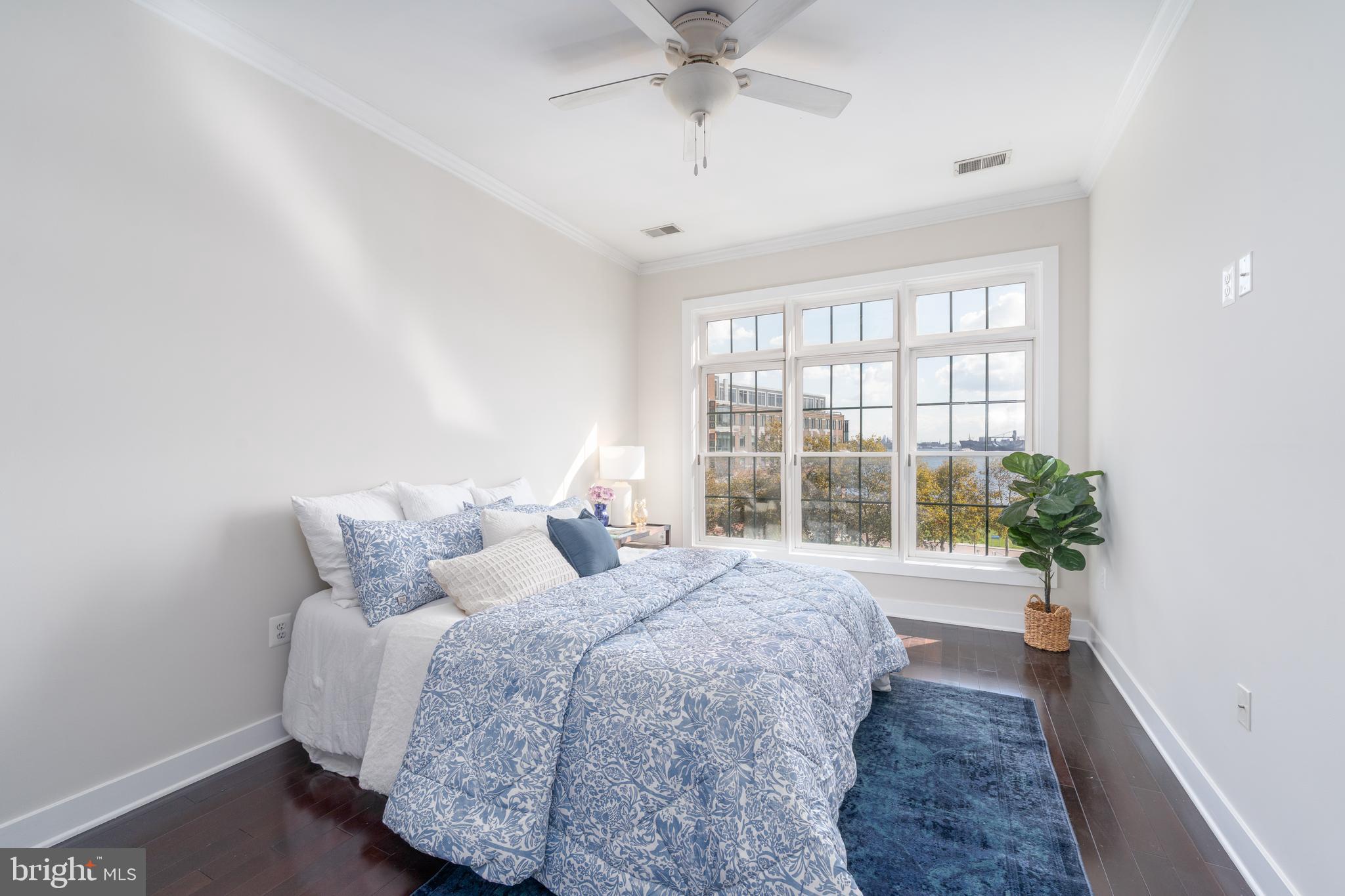 1500 Thames Street, Unit 401 Baltimore, MD 21231 - Photo 16 of 54 a spacious bedroom with a bed and a large window