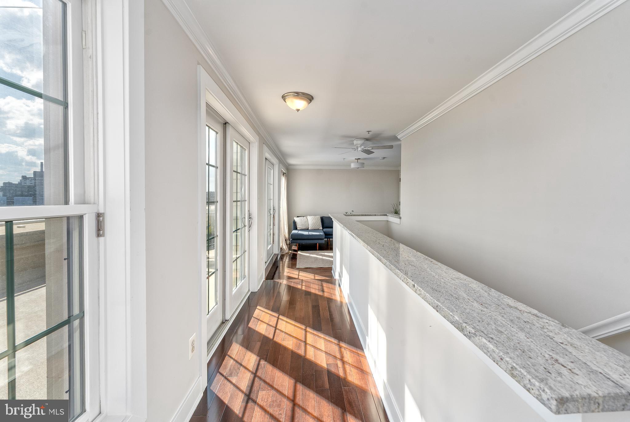 1500 Thames Street, Unit 401 Baltimore, MD 21231 - Photo 21 of 54 a view of a hallway with wooden floor and staircase