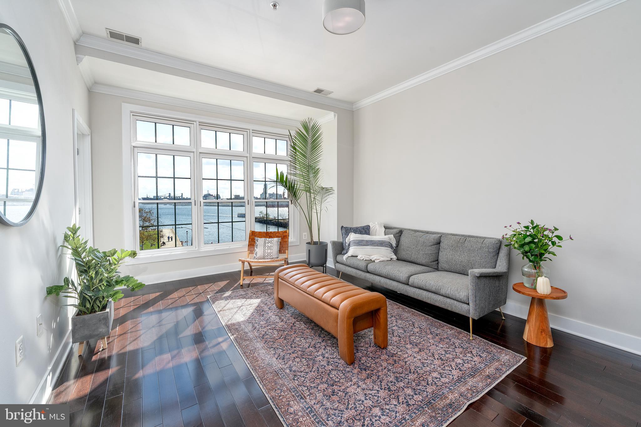 1500 Thames Street, Unit 401 Baltimore, MD 21231 - Photo 3 of 54 a living room with furniture and a potted plant