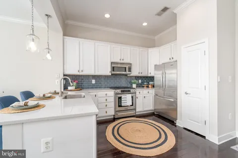 a kitchen with a sink a stove a refrigerator and cabinets