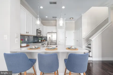 a dining room with furniture a kitchen island and appliances