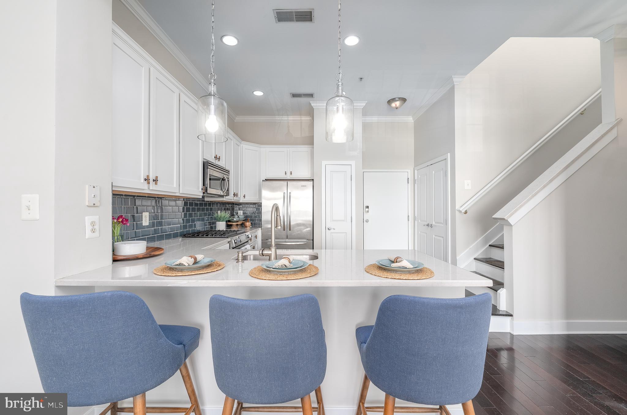 1500 Thames Street, Unit 401 Baltimore, MD 21231 - Photo 5 of 54 a dining room with furniture a kitchen island and appliances