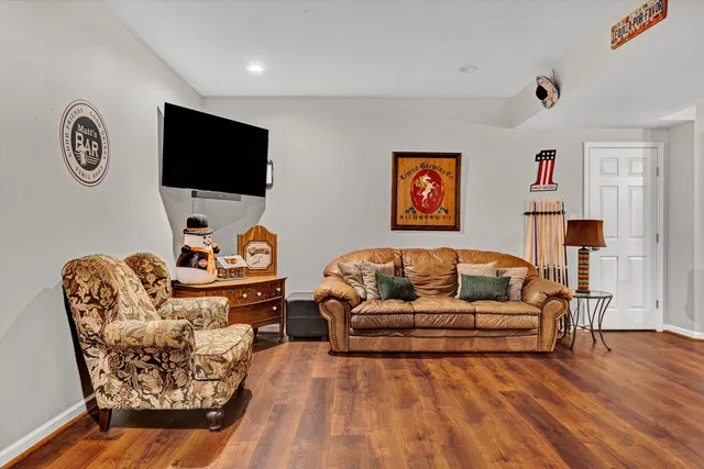 a view of a patio with table and chairs couches under an umbrella with large trees