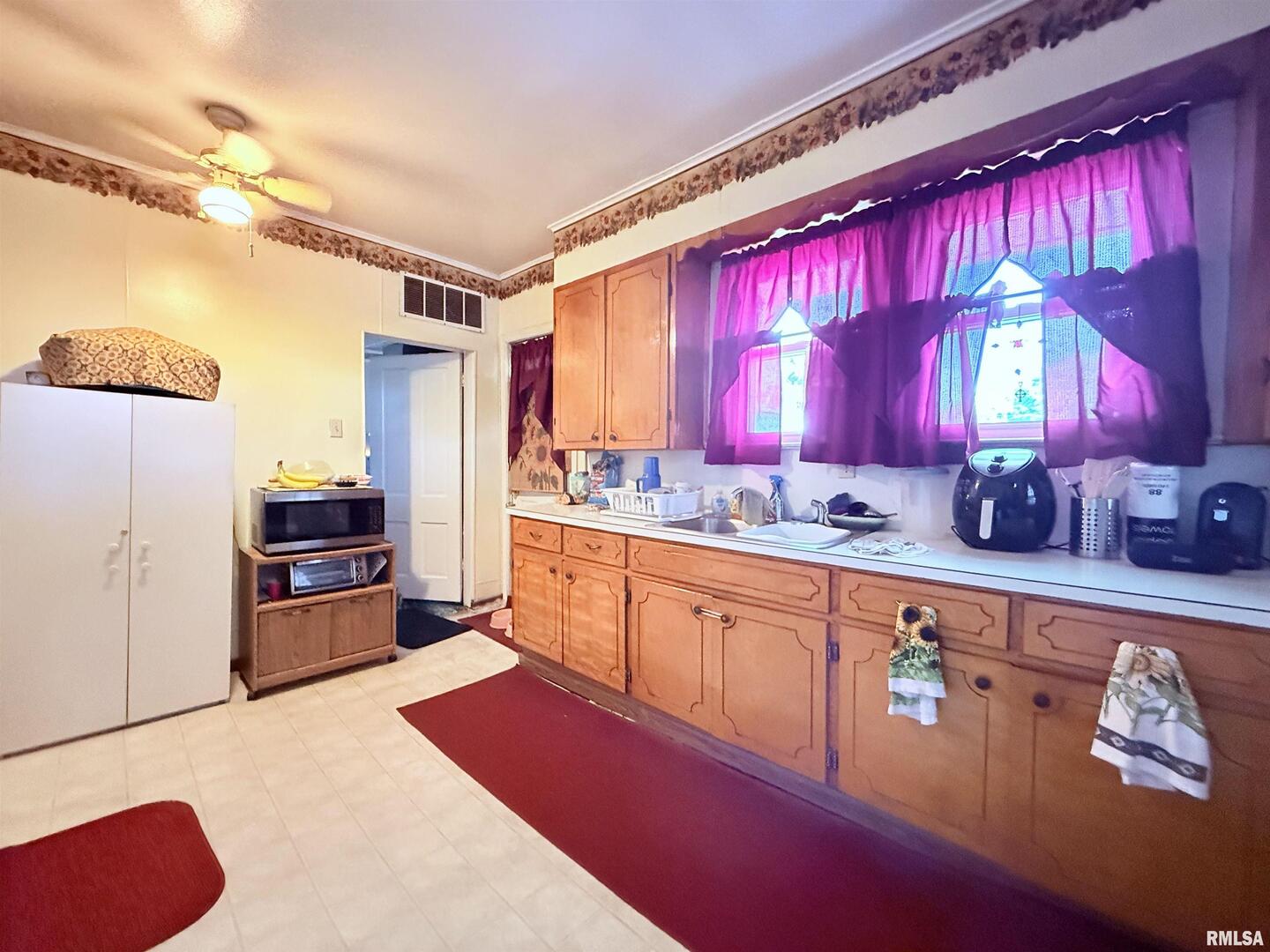 103 Baltimore Street Ridgway, IL 62979 - Photo 16 of 21 a kitchen with stainless steel appliances kitchen island granite countertop a table chairs in it and wooden floors