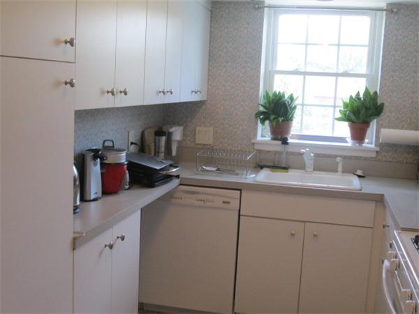 199 Lake Shore Road, Unit 4 Boston, MA 02135 - Photo 4 of 13 a kitchen with stainless steel appliances white cabinets and a window