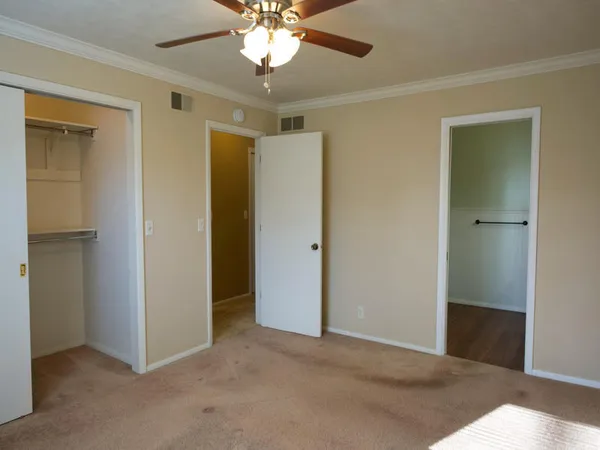 a view of an empty room with a chandelier fan