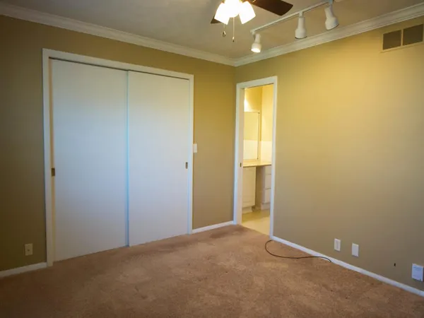 a view of an empty room with a chandelier fan