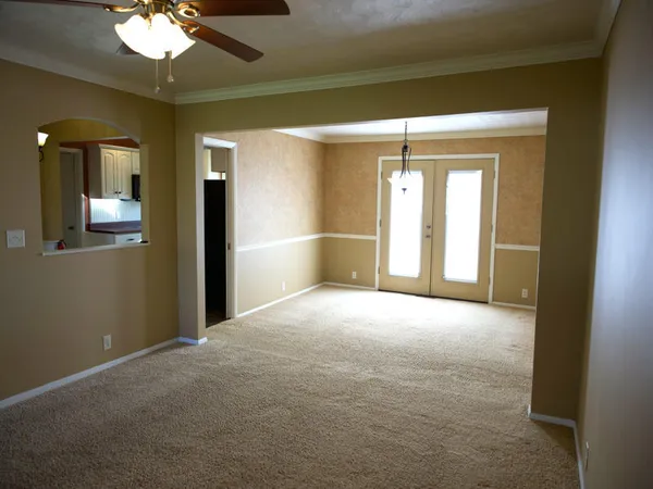 a view of a room with a chandelier fan and bathroom