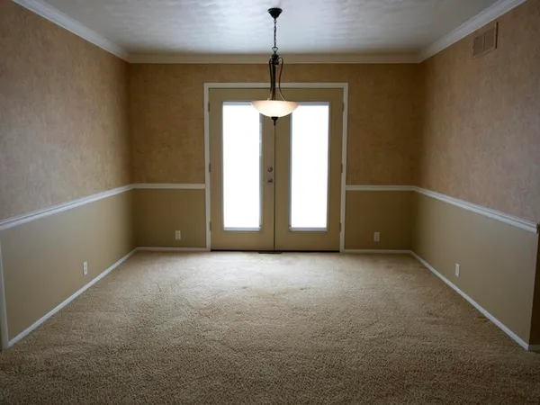 an empty room with windows and entrance