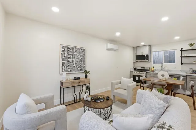 a living room with furniture kitchen and a wooden floor