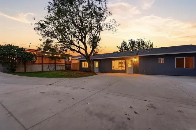 a kitchen with stainless steel appliances a stove a sink dishwasher a refrigerator with a dining table and chairs