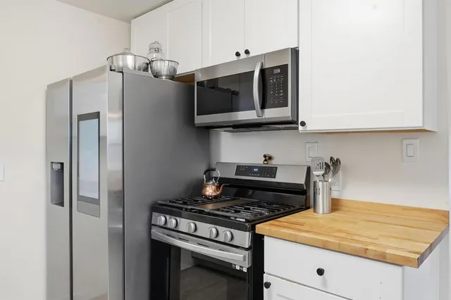 a kitchen with stainless steel appliances granite countertop a stove and a microwave