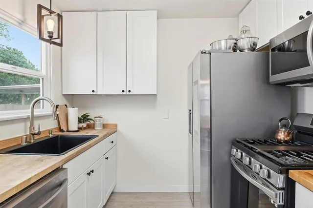 a kitchen with stainless steel appliances granite countertop a sink stove and refrigerator