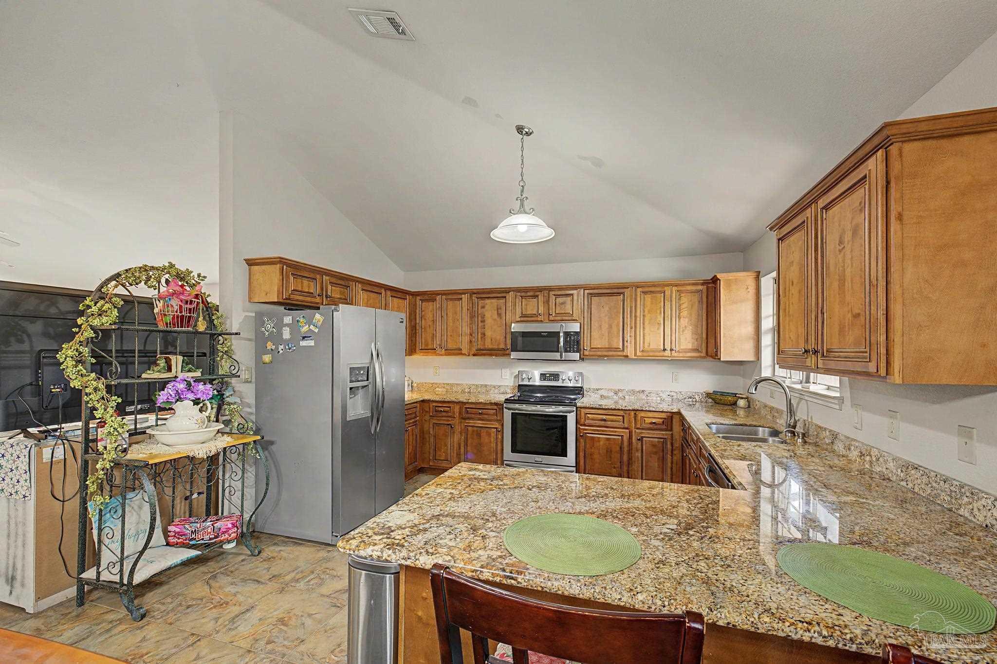 5461 Tucker Circle Pace, FL 32571 - Photo 11 of 52 a kitchen with granite countertop a sink appliances and cabinets