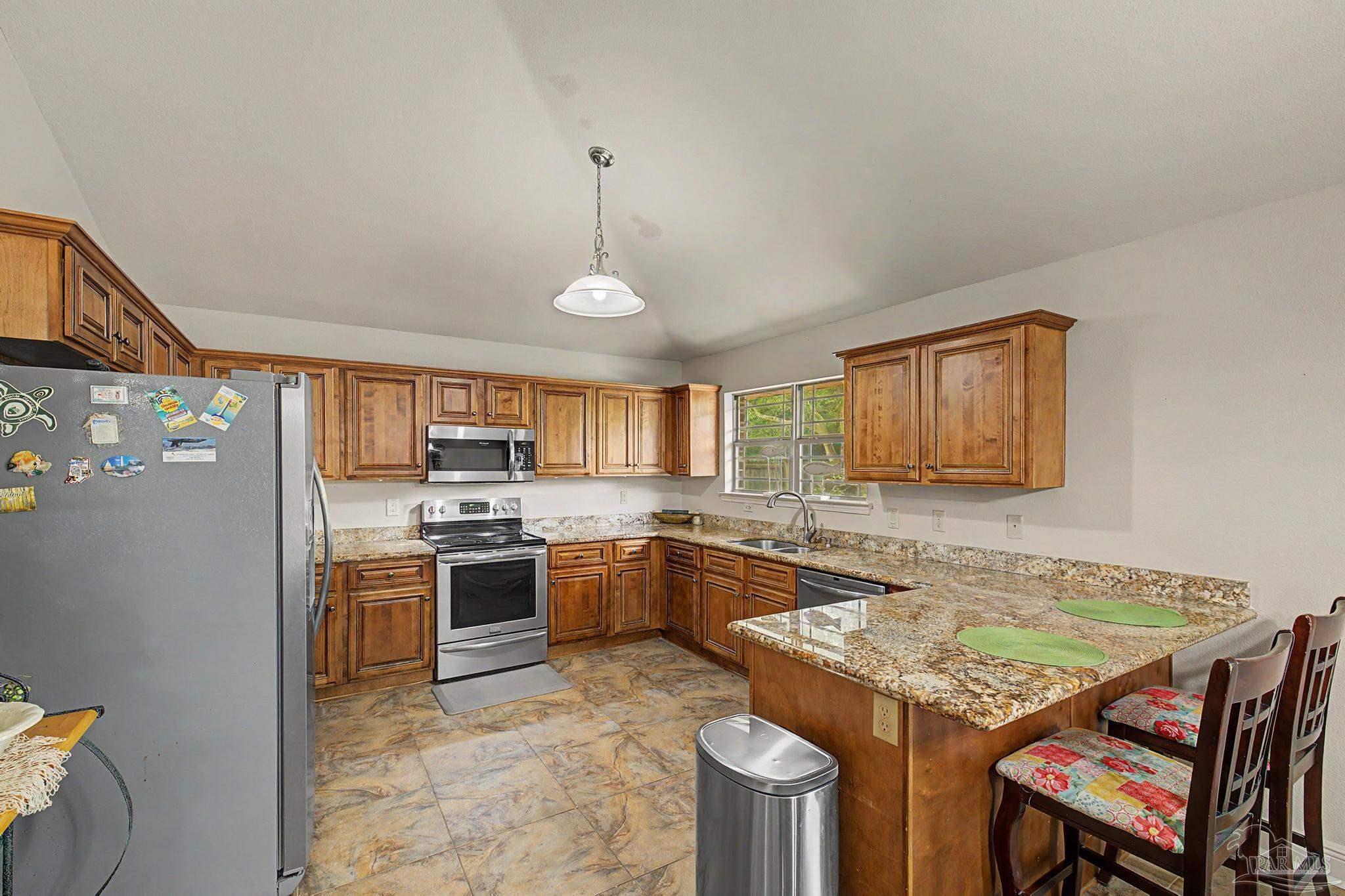 5461 Tucker Circle Pace, FL 32571 - Photo 12 of 52 a kitchen with kitchen island granite countertop a sink stove and refrigerator