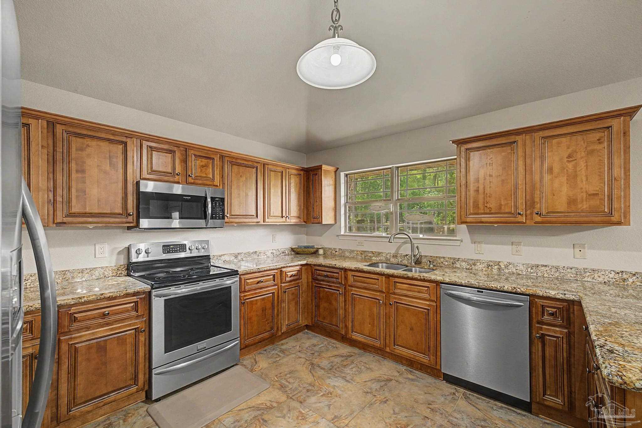 5461 Tucker Circle Pace, FL 32571 - Photo 13 of 52 a kitchen with stainless steel appliances granite countertop a sink stove window and cabinets