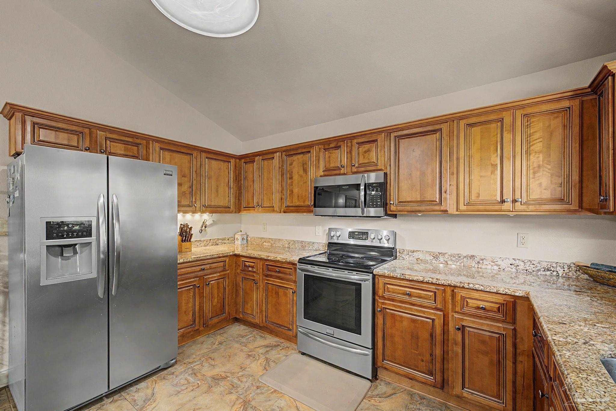 5461 Tucker Circle Pace, FL 32571 - Photo 14 of 52 a kitchen with stainless steel appliances granite countertop a refrigerator stove top oven and sink
