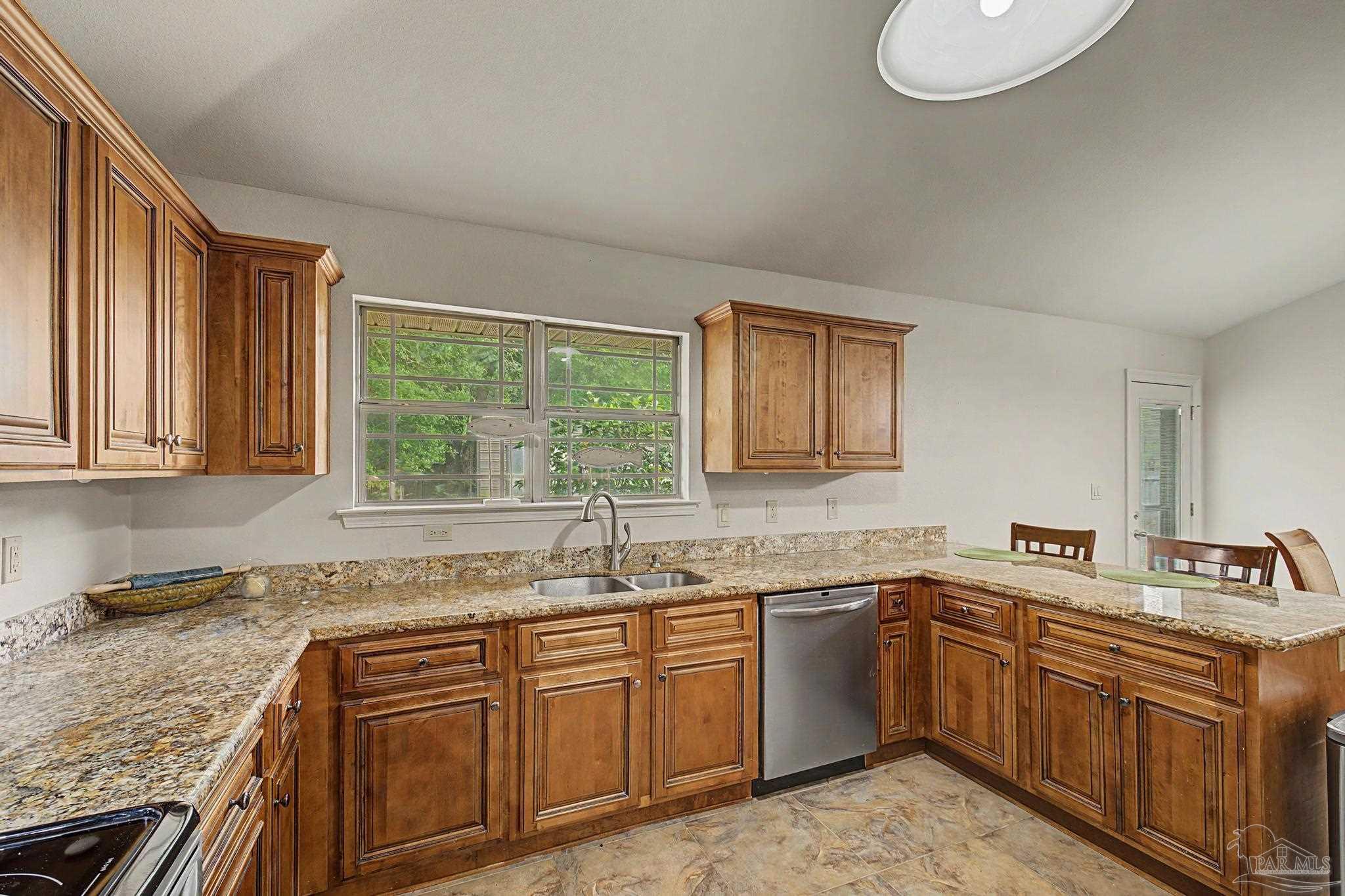 5461 Tucker Circle Pace, FL 32571 - Photo 17 of 52 a kitchen with stainless steel appliances granite countertop a sink stove and cabinets
