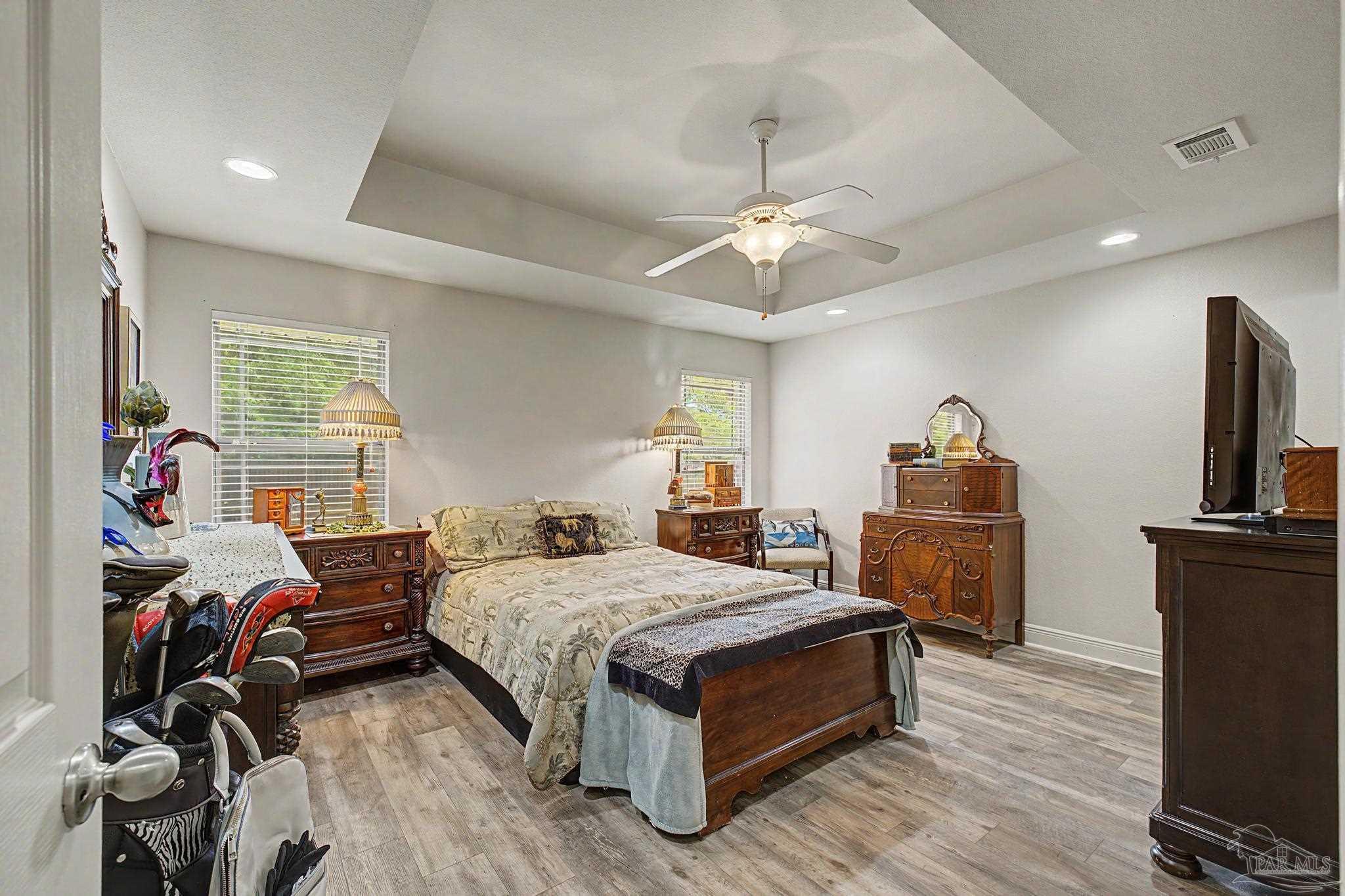 5461 Tucker Circle Pace, FL 32571 - Photo 19 of 52 a bedroom with a bed wooden floor and a chandelier
