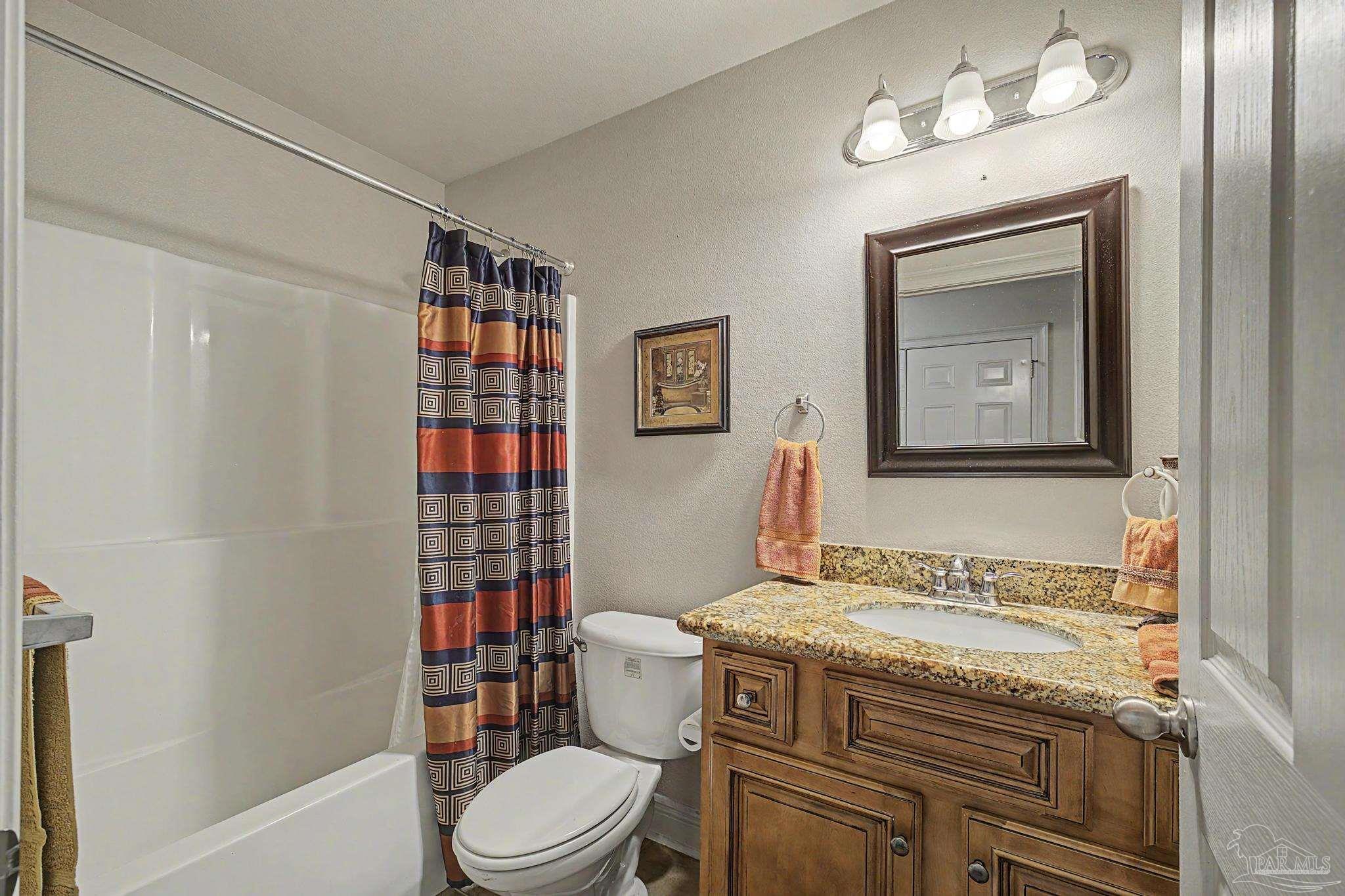 5461 Tucker Circle Pace, FL 32571 - Photo 29 of 52 a bathroom with a granite countertop toilet sink and mirror