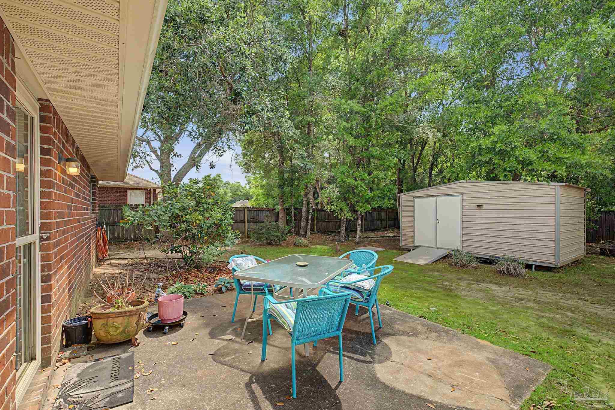 5461 Tucker Circle Pace, FL 32571 - Photo 32 of 52 a view of backyard with seating space and trees