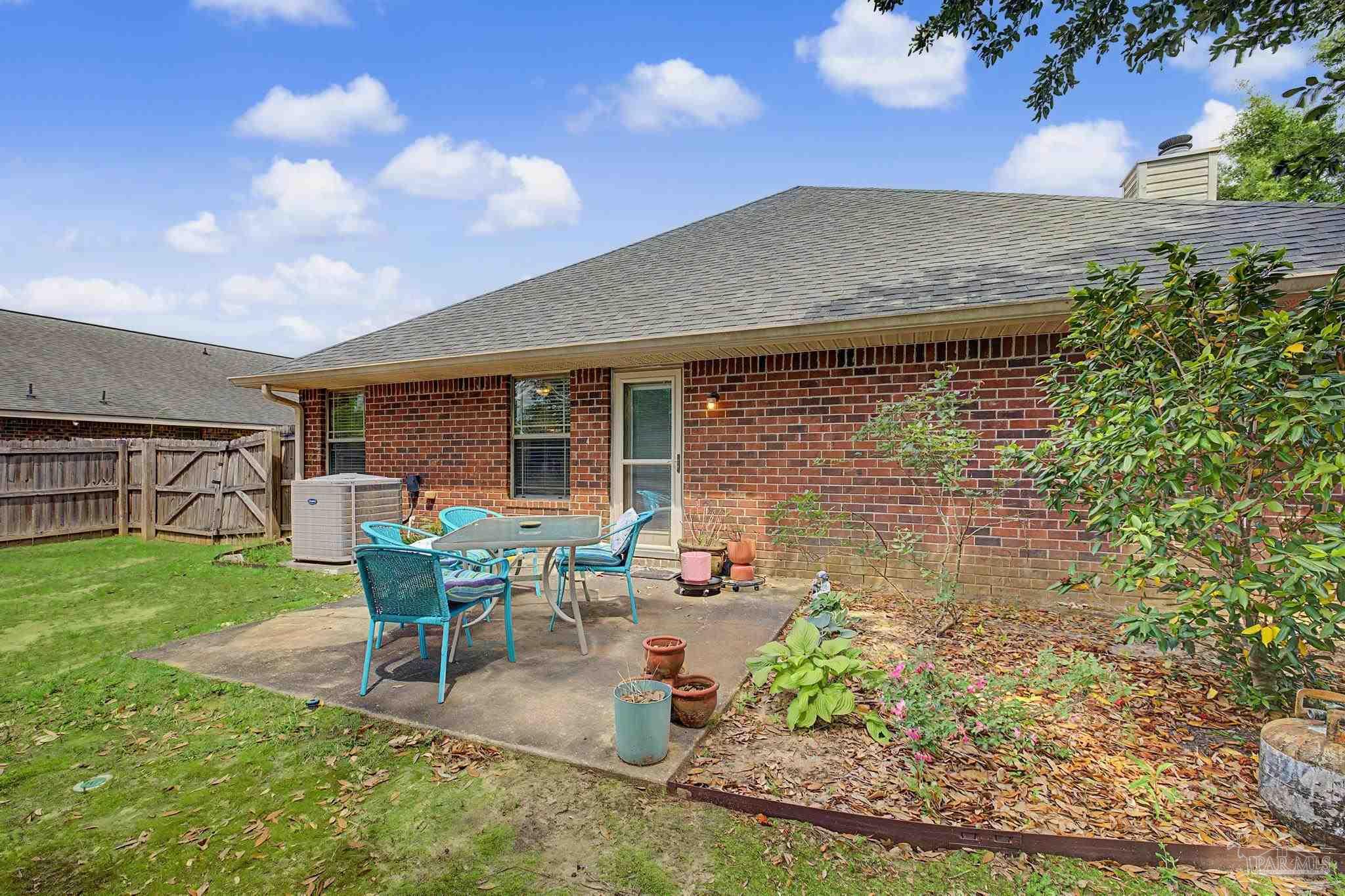5461 Tucker Circle Pace, FL 32571 - Photo 34 of 52 a patio with table and chairs and potted plants